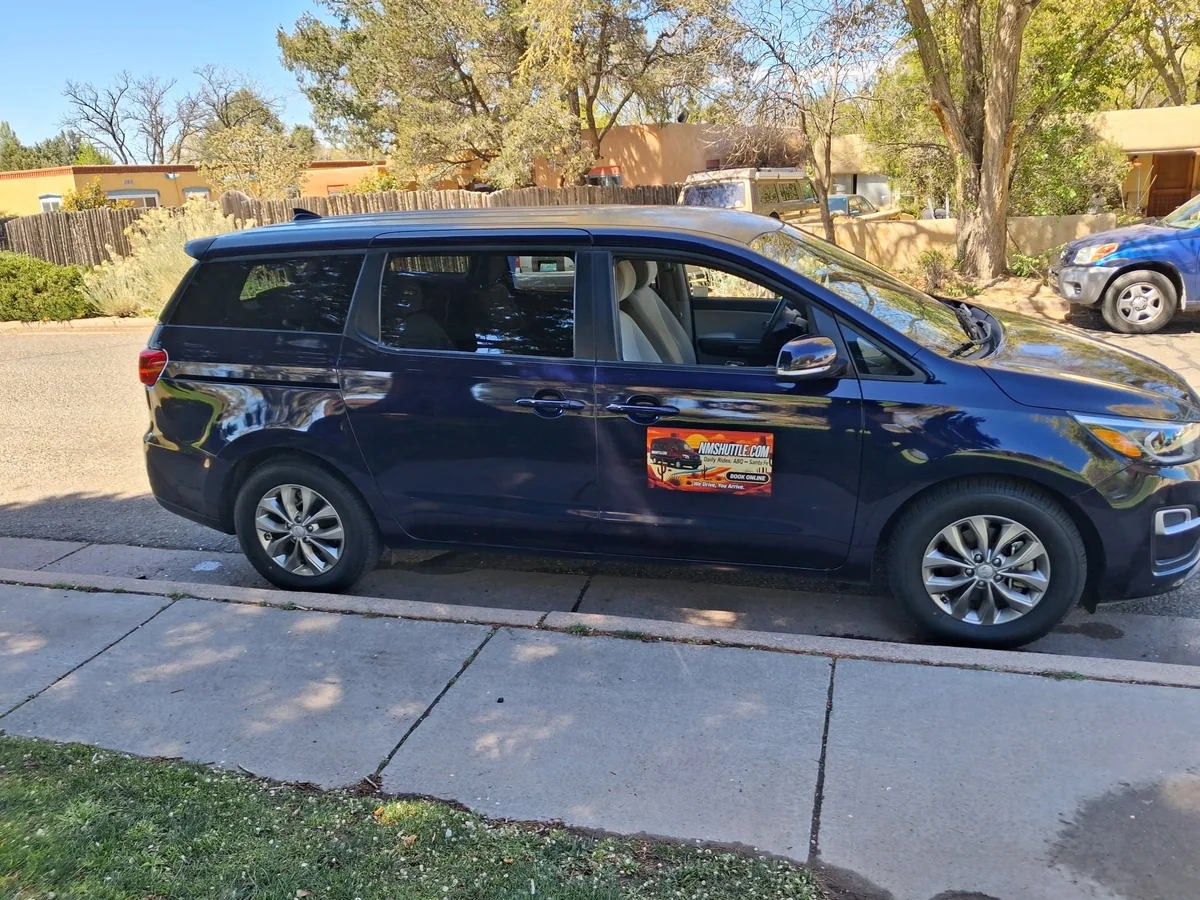 NMShuttle passenger van with branded door sign